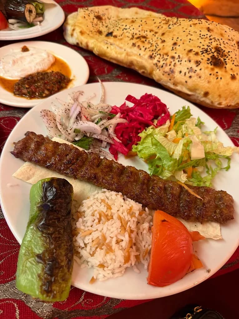 Charcoal grilled Turkish kebab plate served with traditional garnishes