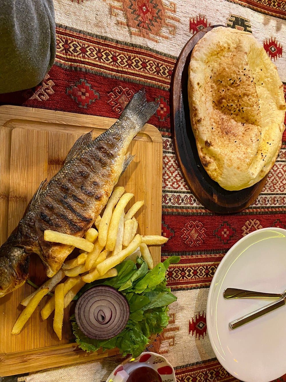 Grilled sea bass served with lemon and greens